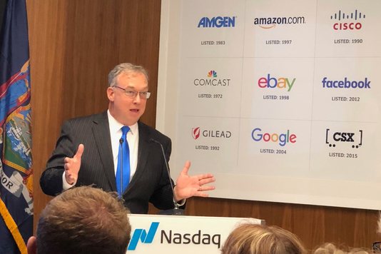 Tom Mack speaking at the Nasdaq lectern at NASDAQ MarketSite